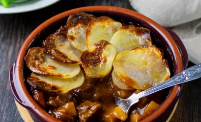 Lancashire Hotpot - lamb stew with sliced potatoes in terracotta dish