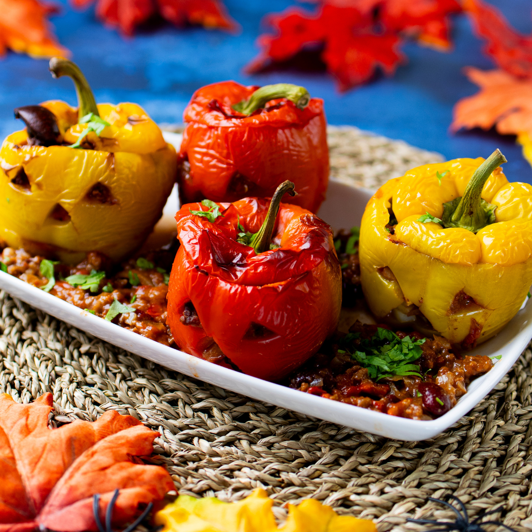 Red & yellow peppers carved like jack-o-lantern pumpkins, stuffed with chilli con carne